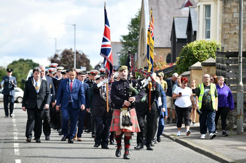 Piper Kevin McLean leads the parade to Laurieston's war memorial.