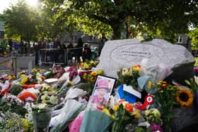 A photo of Queen Elizabeth II left among the flowers laid by members of the public at Balmoral  (Pic: PA/Andrew Milligan)