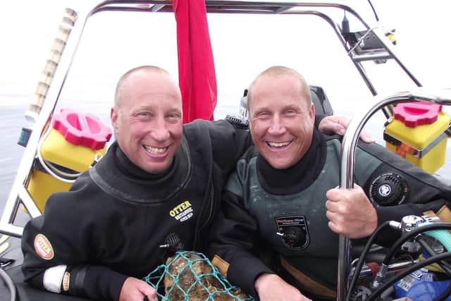 Julian and Lincoln Barnwell with with the bell from the wreck of the HMS Gloucester
Pic: UAE