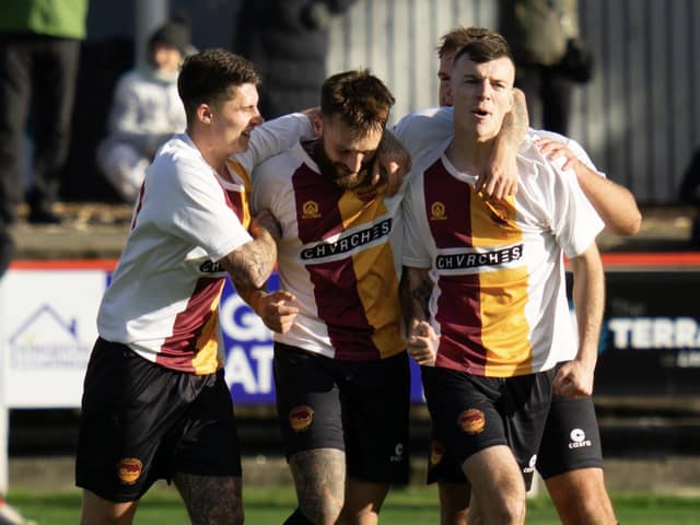 Grant Hamilton is mobbed by his Whitburn team-mates after scoring a late winner against Camelon Juniors on Saturday in the East of Scotland first division (Pictures by Kristopher Dowell)