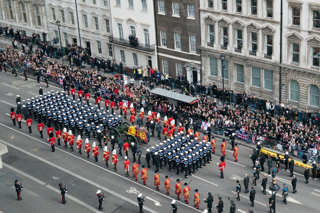 The State Gun Carriage carries the coffin of Queen Elizabeth II, draped in the Royal Standard with the Imperial State Crown and the Sovereign's orb and sceptre, as it leaves Westminster Abbey after the State Funeral of the Queen. Picture date: Monday September 19, 2022.