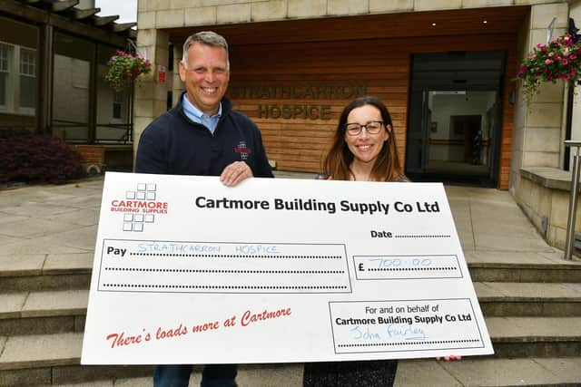 John Fairley, director of Cartmore, hands over a cheque to Claire Kennedy, corporate fundraiser at Strathcarron Hospice. Pic: Michael Gillen