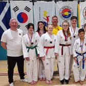 Chief instructor Duncan Irvine (1st left) with his medal-winning students, referee William Ferguson and Grandmaster TK Loh, the head of the TTA