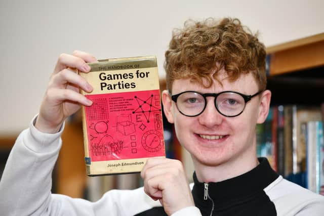 Falkirk Library assistant James Crawford with the copy of The Handbook of Games for Parties by Joseph Edmundson that was returned 51 years late. Picture: Michael Gillen.