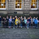 Members of the public stand outside waiting to pay their respects.