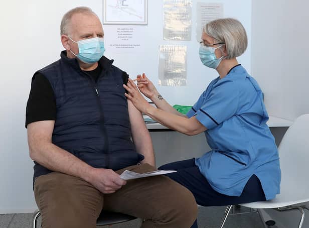 Gillian Bruce co-ordinator with the immunisation team at NHS Forth Valley gives a vaccine to Ian Love from Dunipace at Forth Valley College's Stirling campus. Photo: Andrew Milligan/PA Wire.