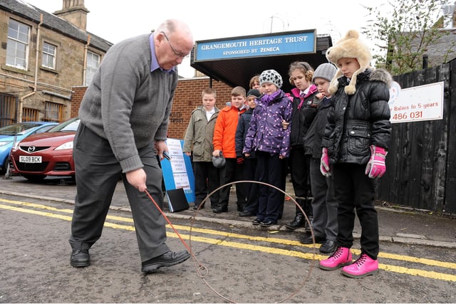 Heritage Trust member showing the children a wartime game.