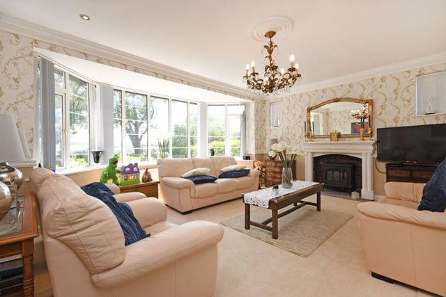 Living room with bay window and feature fireplace with log effect electric fire, French doors into the garden room and further French doors to the rear garden.