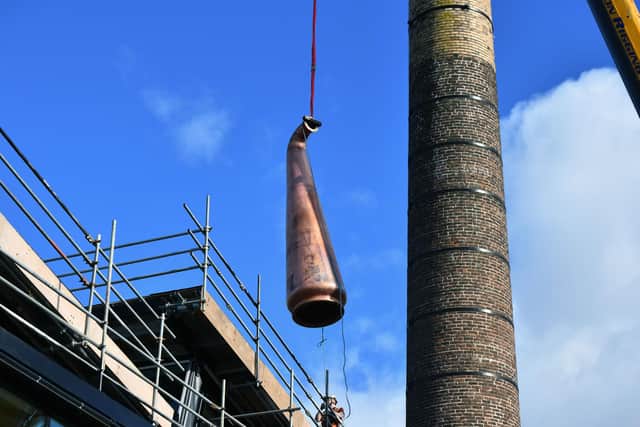 The top of one of the tree stills being lowered into the distillery building