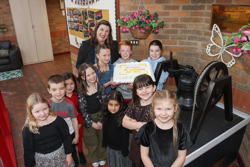 Headteacher Stacey Collier-West with some pupils and a celebratory cake.