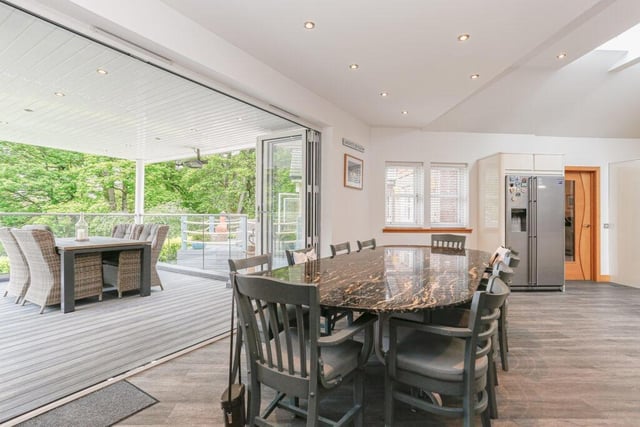 Dining area with bi-fold doors leading to a covered, composite wood decked seating area.