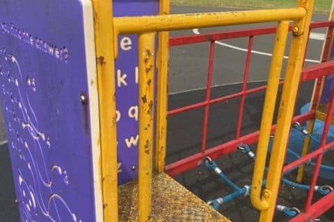 Rust is flaking off the play equipment.