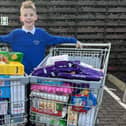 Aaron Clark, who runs his own business The Kandy Kid, raised enough money from a raffle to buy two large trolleys of food to donate to the Kersiebank Community Project's Foodbank.  (Pic: Submitted)