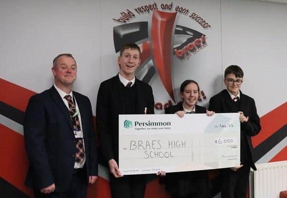 Headteacher Iain Livingstone alongside pupils receiving the cheque from Persimmon.  Pic: Contributed