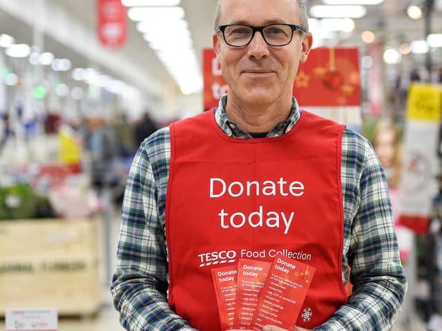 A Tesco volunteer holding a shopping list guide for donations at the launch of the  festive campaign