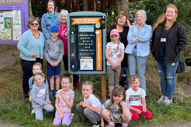 Children and staff from Kidz Stop next to one of the newly installed litter picking boards.
