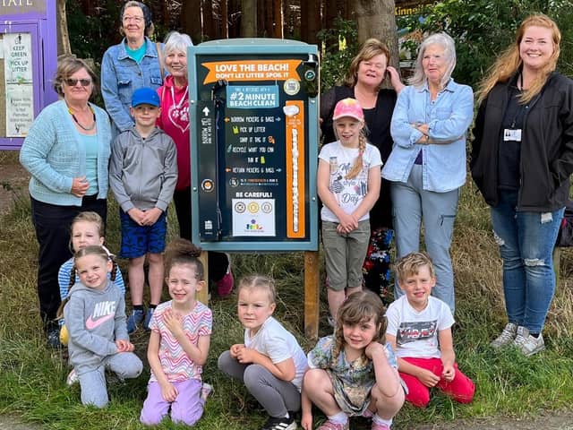Children and staff from Kidz Stop next to one of the newly installed litter picking boards.