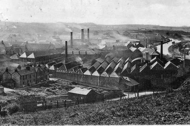 Smoke billows from the chimneys of industrial Bonnybridge, with the canal in the far right