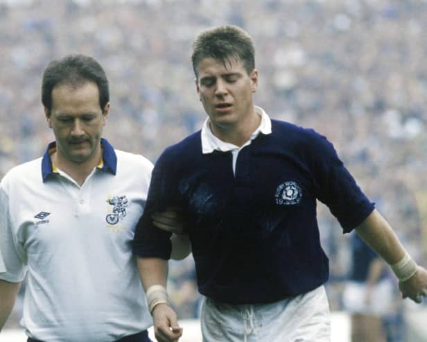 MYSTERY PLAYER: Who is this former Scotland half-back, pictured in 1991being helped off (Photo: SNS Group)