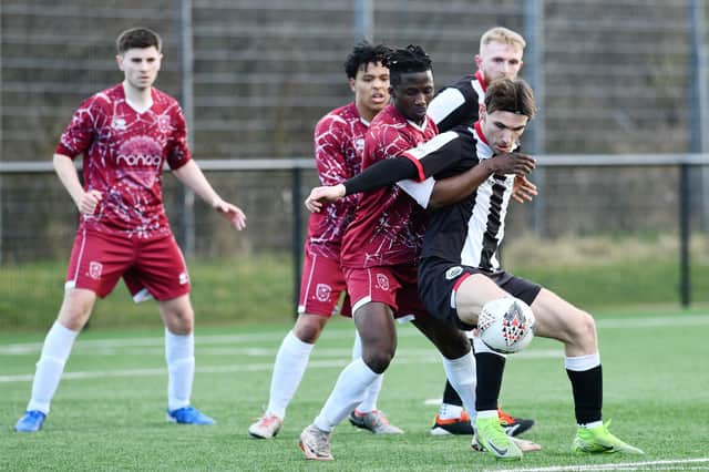 Dunipace forward Sam Colley fends off his Tynecastle opponent (Photo: Michael Gillen)