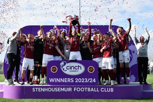 Stenhousemuir players and coaching staff celebrate as captain Gregor Buchanan lifts the League Two trophy after a 1-1 draw with Bonnyrigg Rose at Ochilview (Photo: Michael Gillen)