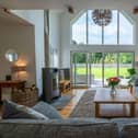 The centrepiece of the house is a magnificent open-plan living, dining, and kitchen area that boasts a vaulted ceiling and cathedral-style windows that flood the house with natural light. The main living space features a modern wood-burning boiler stove which creates a beautiful natural focal point and significantly reduces your dependence on gas by providing cost-effective heating and hot water in the winter months if you choose to use it.