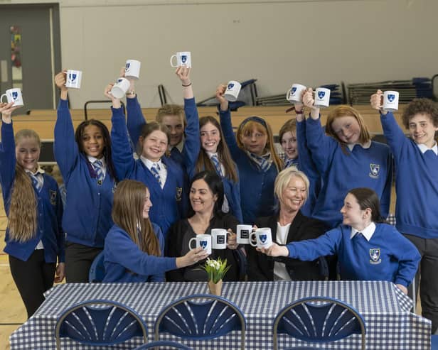P7 pupils at Linlithgow Primary have launched a monthly Blether Cafe as a social enterprise and to raise money for the West Lothian School Clothing Bank. Pictured with pupils are LPS acting deputy headteacher Mrs Matos and Susan Wynn, sales consultant from Cala Homes (East). (Pic: Chris James)