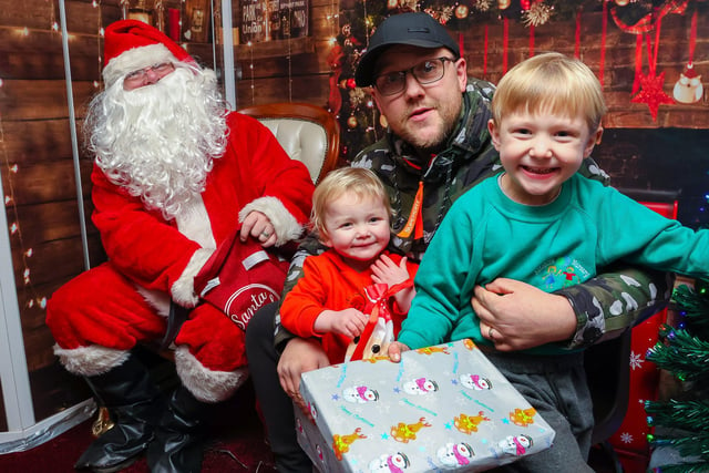 Jamie with his sons Max, 2, and James, 4, from Bonnybridge, meet Santa when his grotto visited Antonine Primary this week.