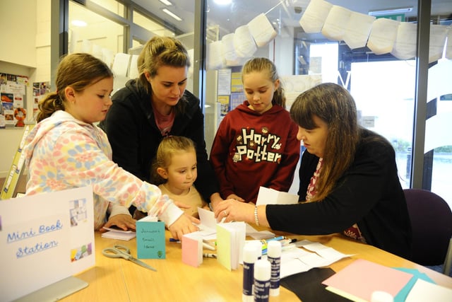 Sisters Isla, eight, Quinn, four, and Ellie, nine, with mum Louise Williams enjoy learning how to make a mini book with help from staff member Jennifer Hosie.