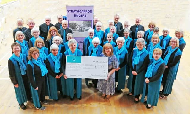 Linda Marshall, secretary of the Strathcarron Singers, hands over a cheque for £5000 to Marjory Mackay, director of nursing at Strathcarron Hospice.  (Pic: submitted)