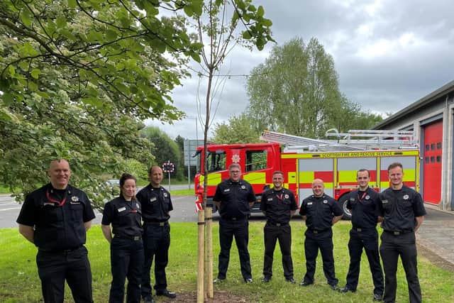 Crew members at Falkirk fire station with the cherry tree they planted for the Queen's jubilee