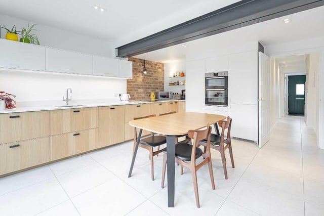 Bright LED spotlights and under counter lighting flood the kitchen with light, high quality worktops sit above the units, whilst an exposed brick wall adds a touch of contemporary finesse.