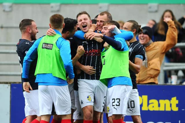 Dixon is mobbed by team-mates after his wonder strike