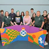 Hayley English from SAS holds the mural with Forth Valley College students and lecturers Angie McLaren and Michael Denzey