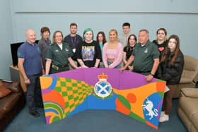 Hayley English from SAS holds the mural with Forth Valley College students and lecturers Angie McLaren and Michael Denzey