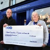Bo'ness charity runner Eddie Hughes presents a cheque for £5150 to Angela Mason, store manager Cancer Research UK shop in Linlithgow.