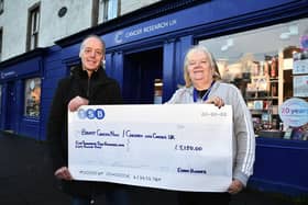 Bo'ness charity runner Eddie Hughes presents a cheque for £5150 to Angela Mason, store manager Cancer Research UK shop in Linlithgow.