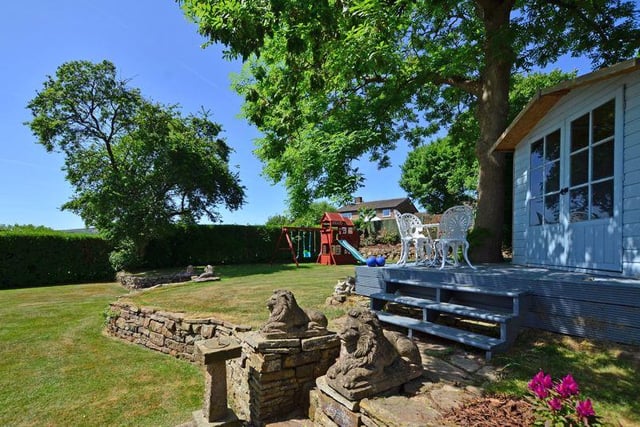 To the rear of the property are generous tiered lawned gardens, play area, summer house and access to a courtyard.