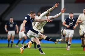 Finn Russell  kicks upfield as Henry Slade of England attempts to charge down during Scotland 11-6 win at Twickenham (Photo by Mike Hewitt/Getty Images)