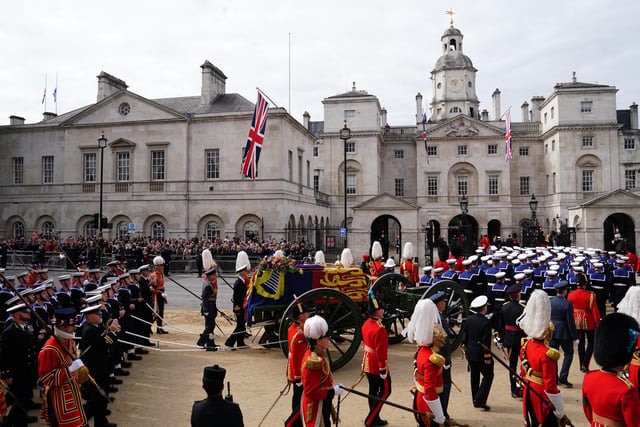 The State Gun Carriage carries the coffin of Queen Elizabeth II, draped in the Royal Standard with the Imperial State Crown and the Sovereign's orb and sceptre, in the Ceremonial Procession following her State Funeral at Westminster Abbey, London. Picture date: Monday September 19, 2022.