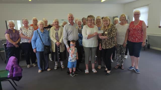 Margaret Paton, chairperson of Laurieston Old Folks Welfare Association, accepts a cheque for £500 from Rotarians Charlie Morrison and Mary Sneddon. (pic: submitted)