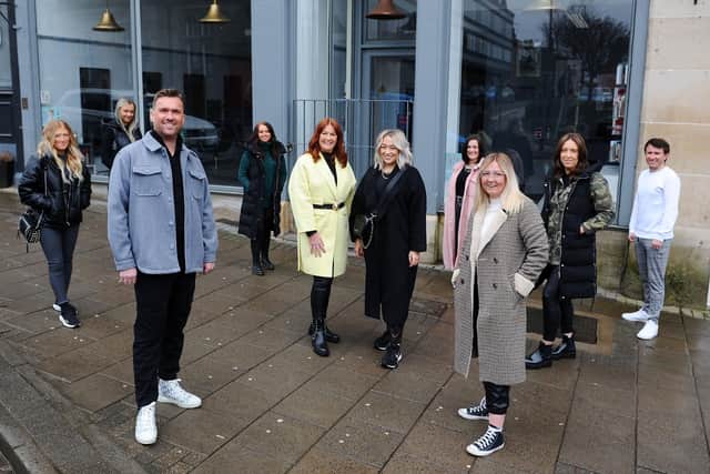 Tweedie and Marshall staff, including stylist Justine Weir (fifth from right), celebrated their 10th anniversary on March 14. Owners Anthony Tweedie and Connie Marshall (front). Picture: Michael Gillen.