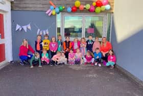 Pupils and staff at St Margaret's Primary School in Polmont have rallied round Jack Robinson (centre, wearing orange and black top) in support of Muscular Dystrophy UK's Go Bright campaign. Contributed.
