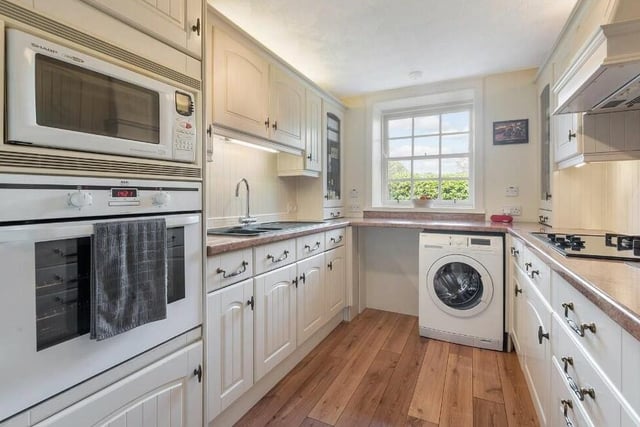 The kitchen is fitted with a range of wall and base units and a host of appliances, included in the sale.