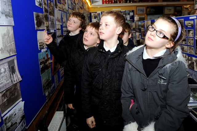 Pupils looking at photographs on display.