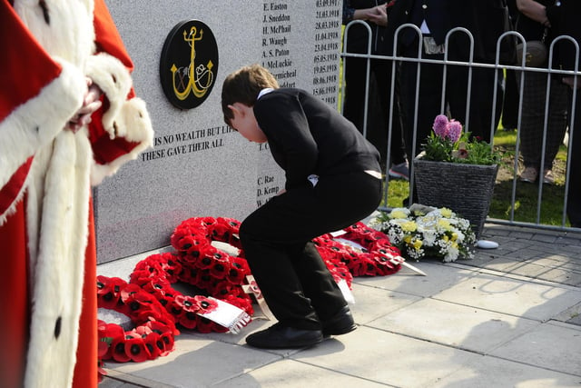 School children laid poppy wreaths and wooden crosses at the memorial