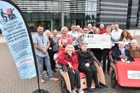 Cycling Without Age receive a cheque from Ineos staff from their annual Tour de France cycling challenge. Pic: Contrbuted