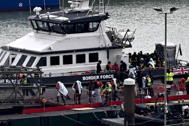 Migrants are escorted ashore from the UK Border Force vessel 'BF Ranger' in Dover, southeast England, on Monday, after having been picked up at sea while attempting to cross the English Channel. Picture: AFP via Getty Images