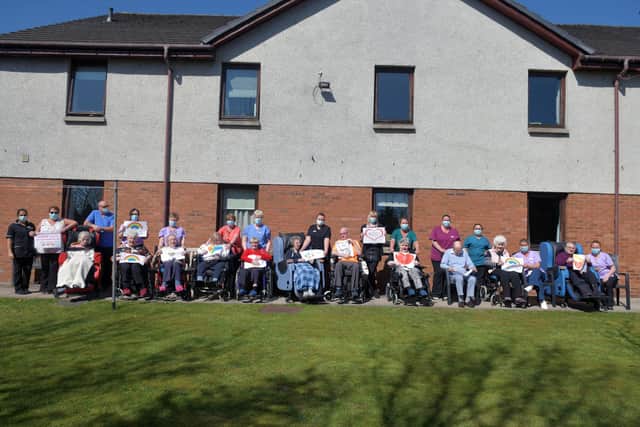 Staff and residents of Carrondale Nursing Home in Carron hold up messages and best wishes to relatives