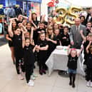 Alex Totten does the honour by cutting the Howgate's 35th birthday cake with help from Project Theatre youngsters.